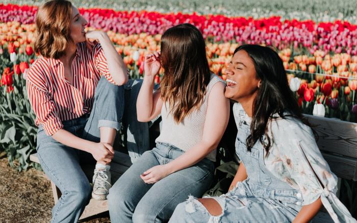 Three women laughing in a park